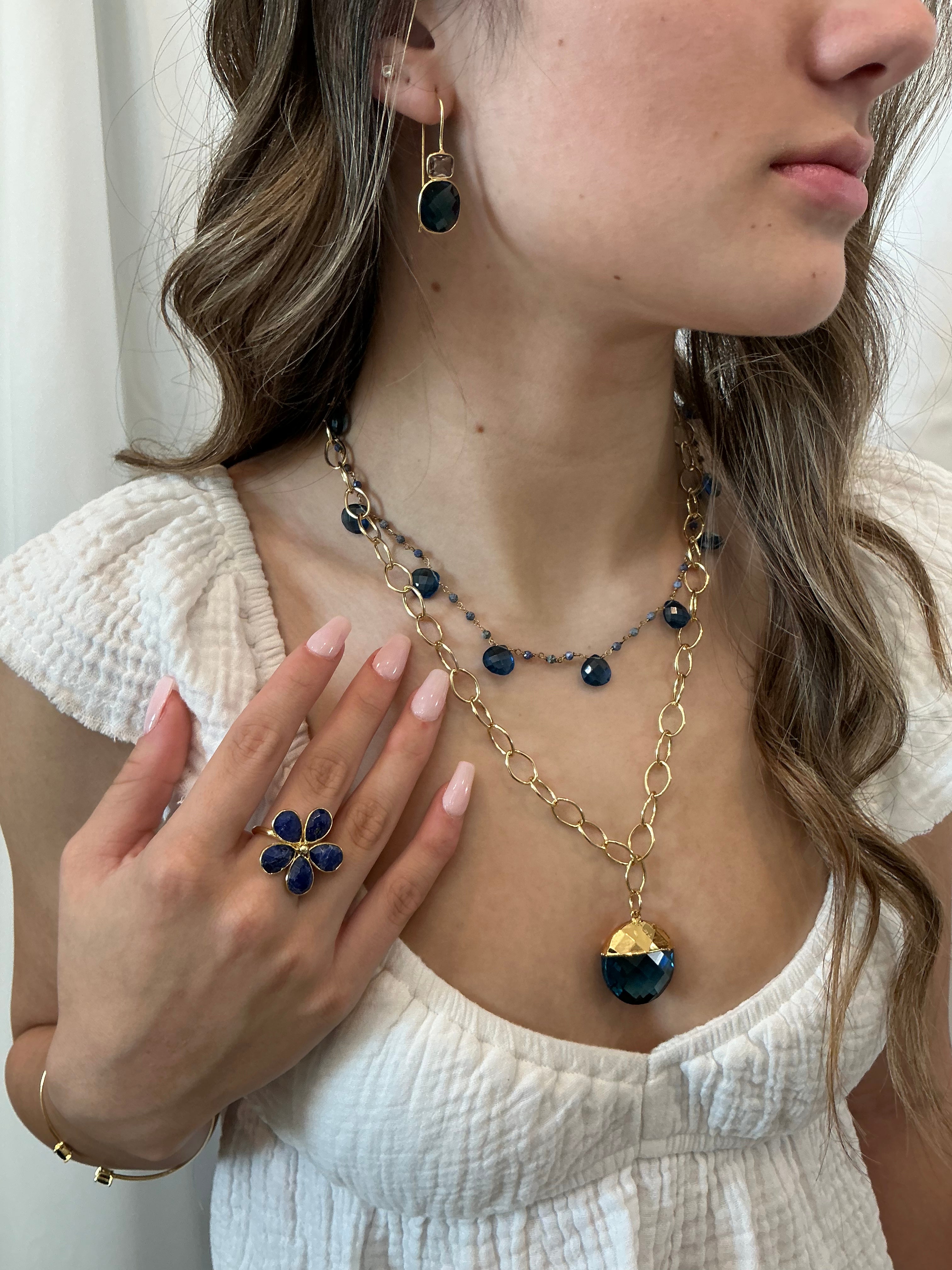 Elegant handmade gemstone jewelry featuring blue necklaces, earrings, and rings, showcasing artisanal, luxury design and style.